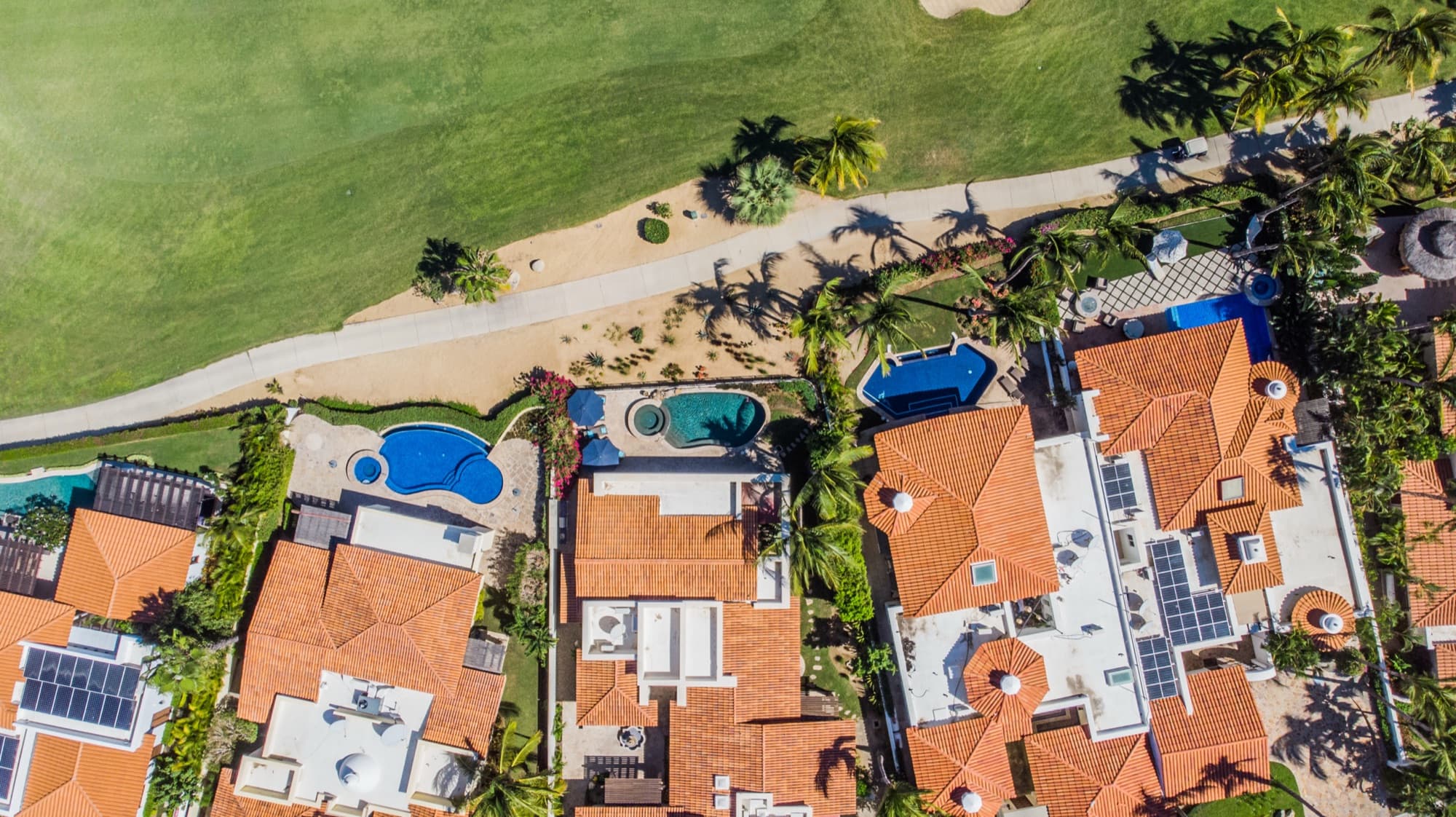 Aerial view of Oceano Alta homes with pools beside the Palmilla golf course