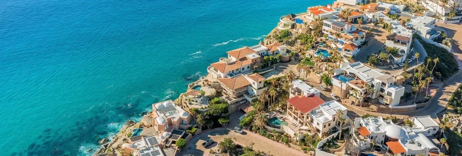 Pedregal homes on the hillside above turquoise water in Cabo San Lucas