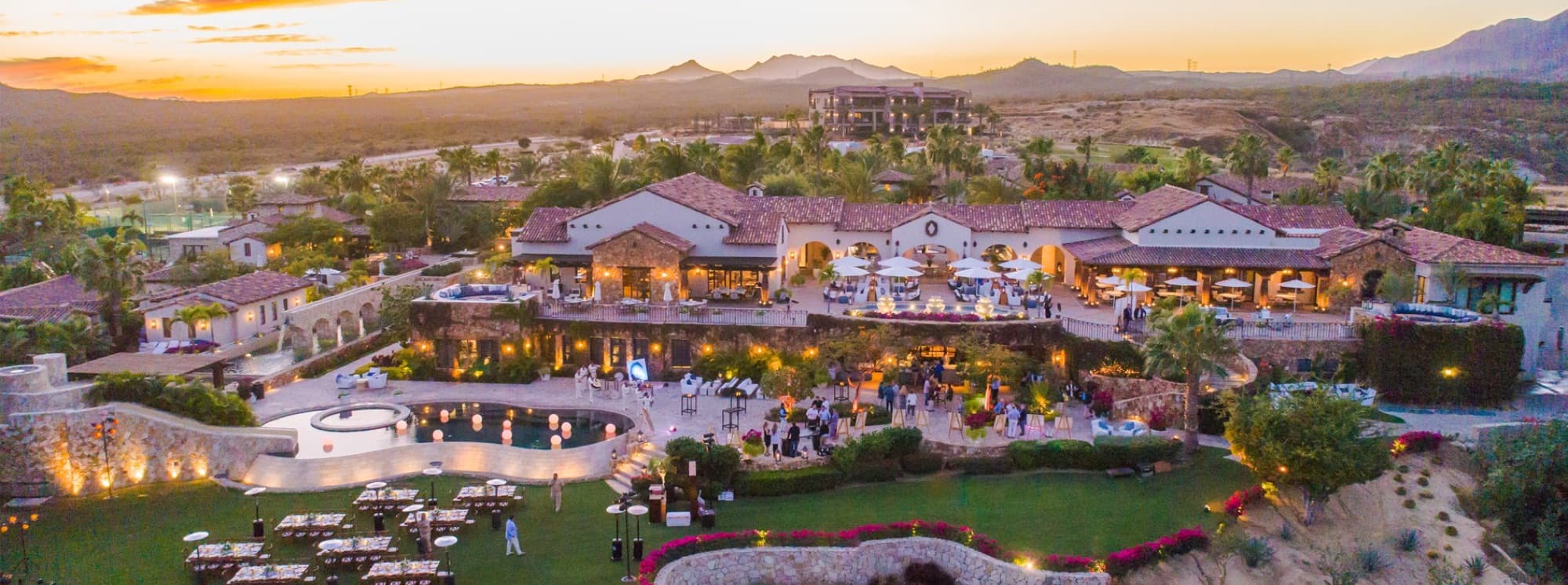 Aerial view of the Querencia clubhouse and pool terraces at dusk