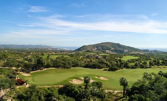 Querencia Tom Fazio golf course green surrounded by desert hills and ocean views